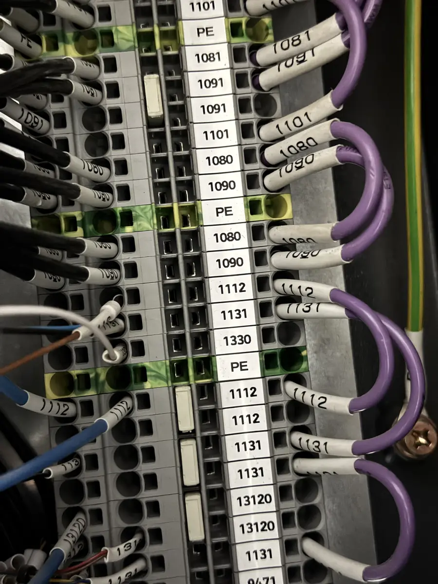 Control panel terminal strip with every conductor ferrule-numbered and matched to its printed terminal label.