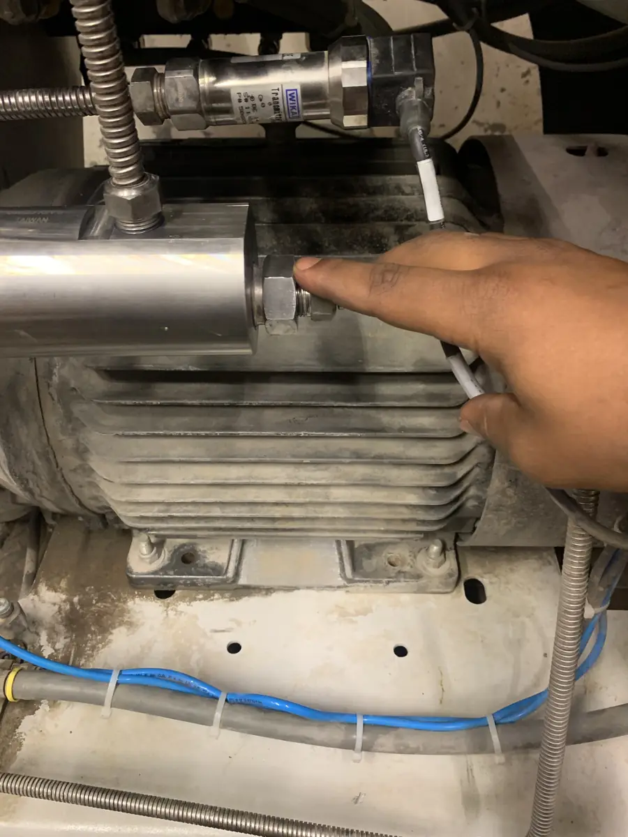 High-pressure manifold block and WIKA pressure transmitter on a direct-drive pump motor assembly.